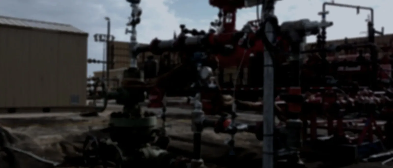 Wellsite photograph showing surface equipment and treatment iron in the field.